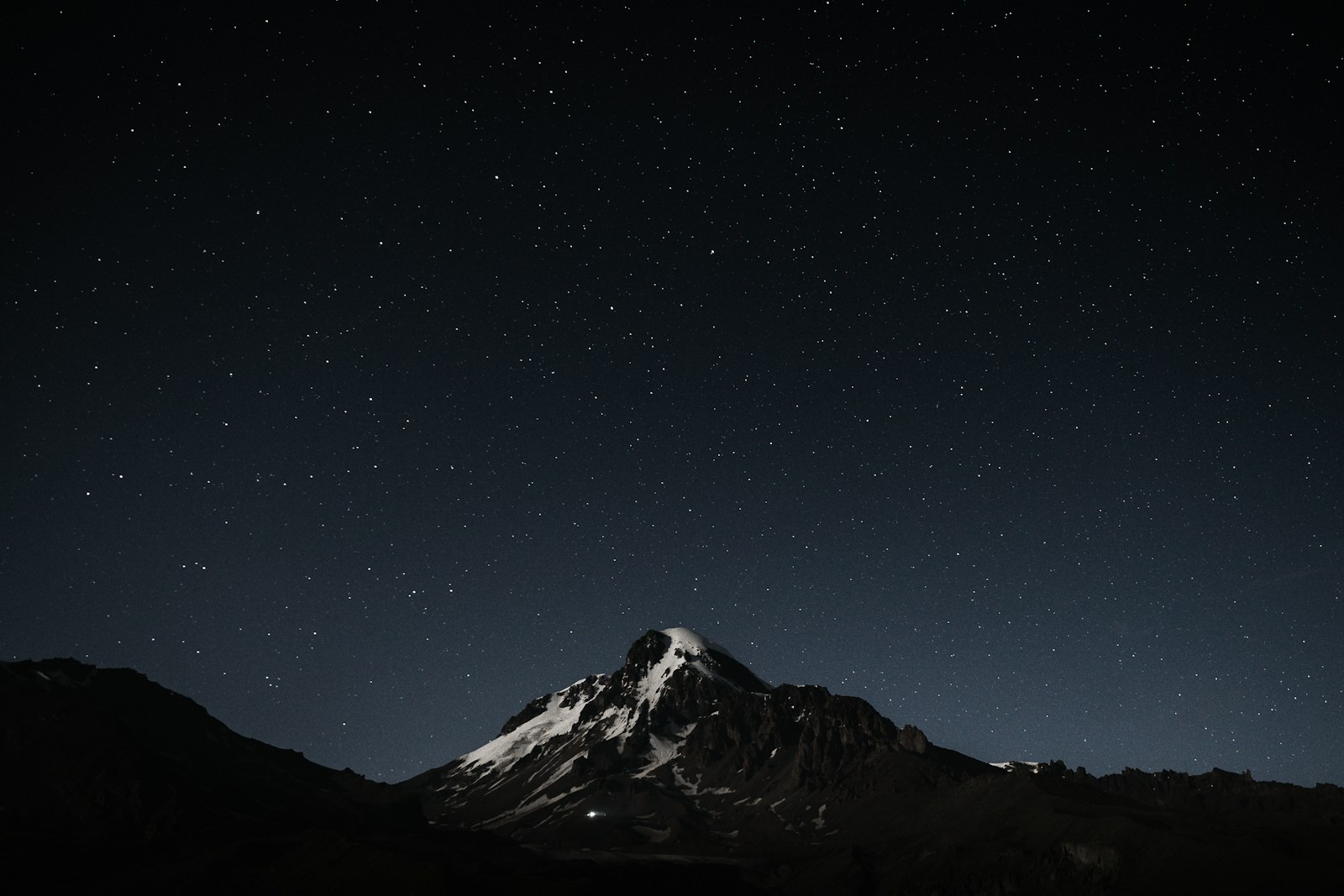 The night sky with stars above a mountain